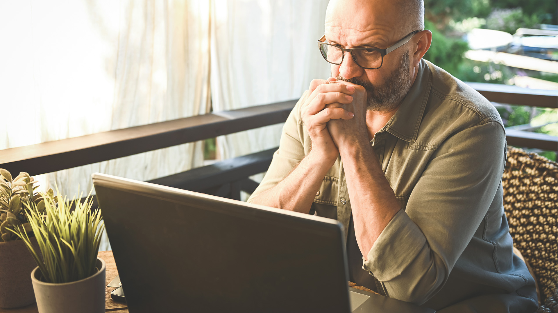 Mann vor Laptop mit verzweifeltem Gesichtsausdruck